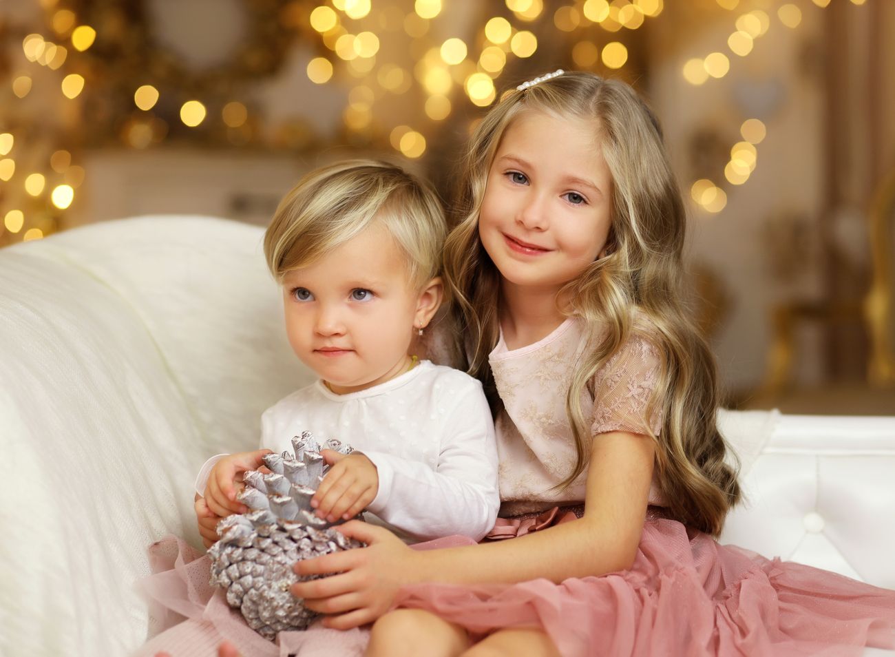 Vánoční fotografie holčičky držící miminko v luxusním vánočném ateliéru | © Fotoprome.cz
