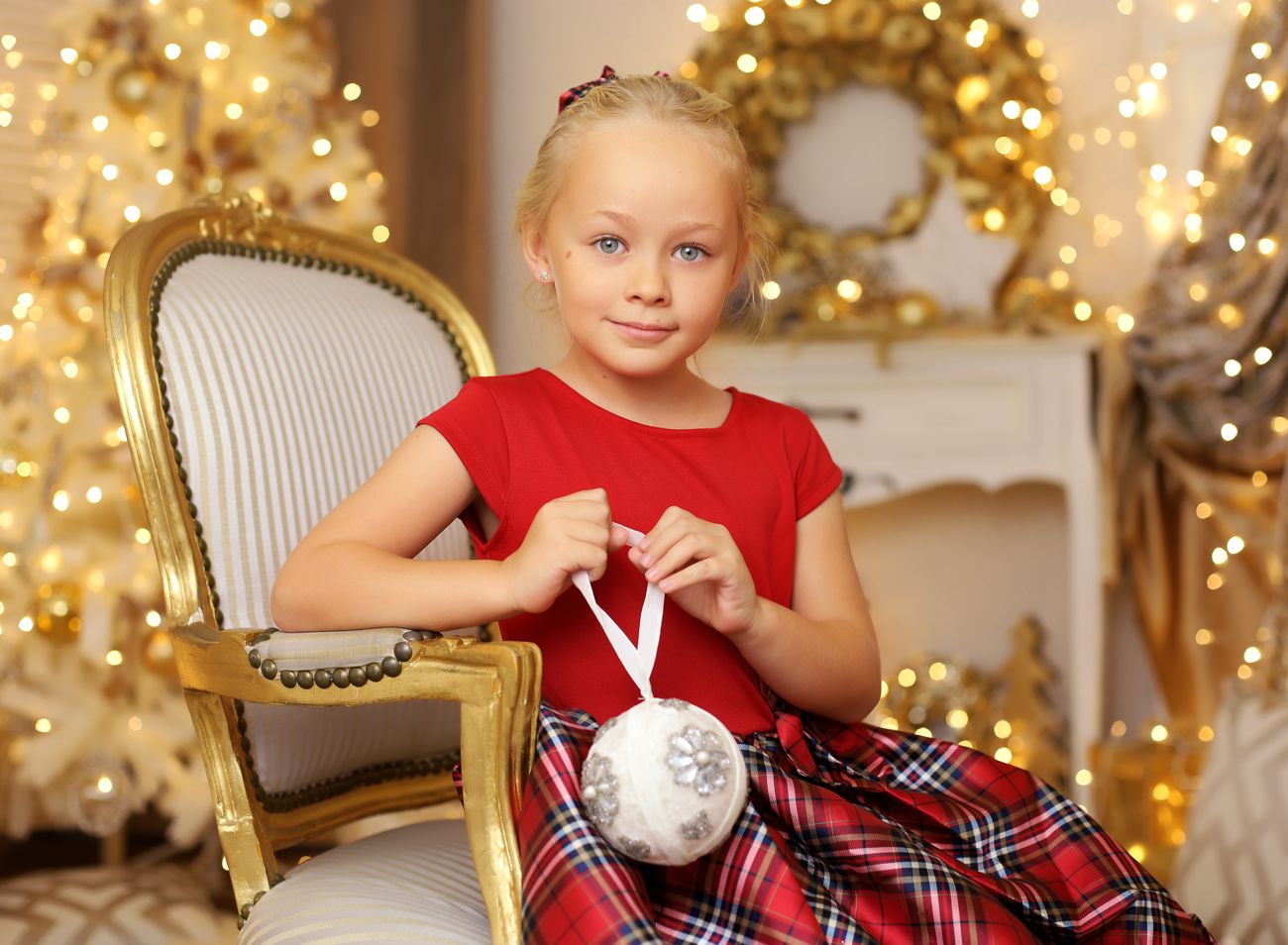 Mladá dívka v červených šatech a vánoční ozdobou v luxusním ateliéru  | © Fotoprome.cz