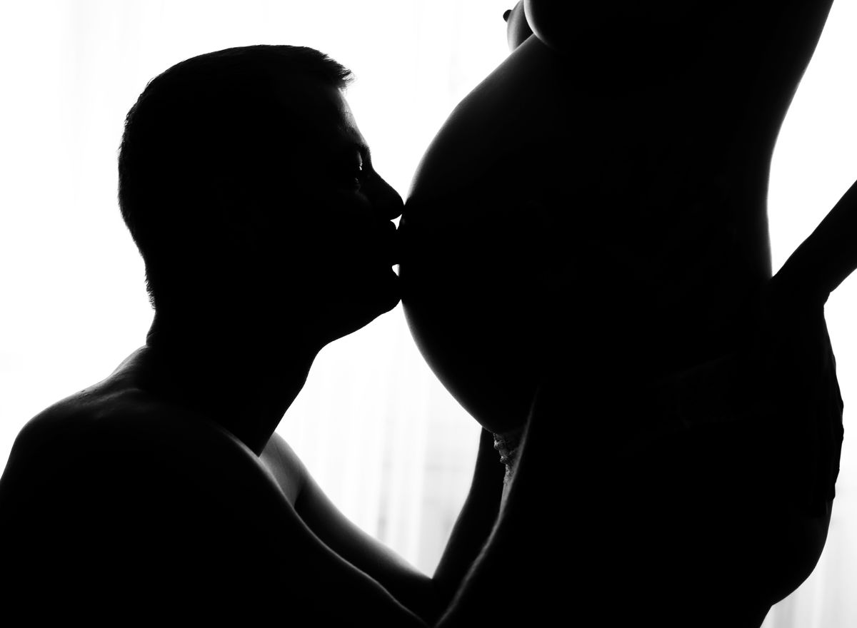 Černobílý těhotenský akt s detailem bříška a partnerem