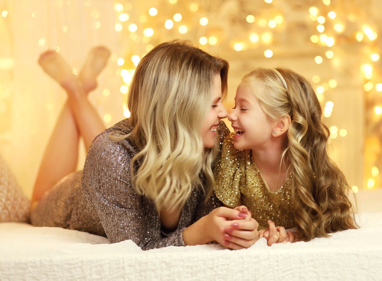 Rodinná vánoční fotografie máma a dcera v ateliéru s vánočními světýlky