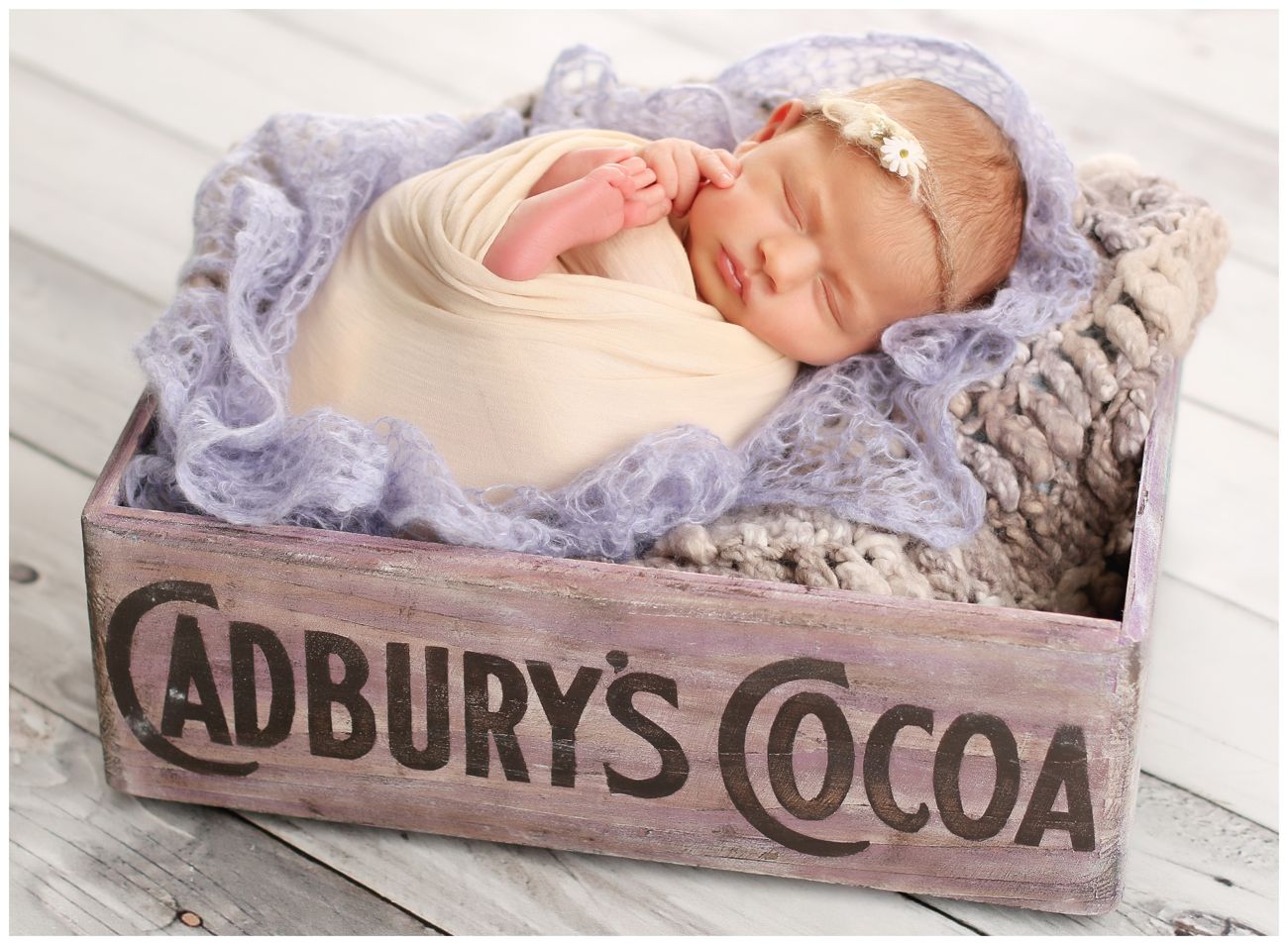 Fotografie novorozeného miminka s čelenkou v bedýnce od kakaa