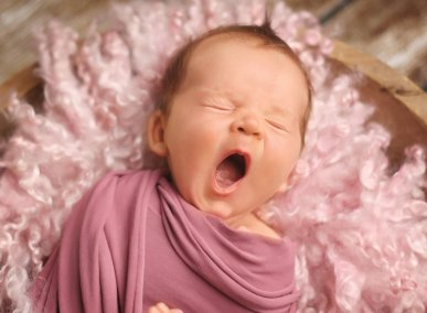 Zívající novorozené miminko při ateliérovém newborn focení