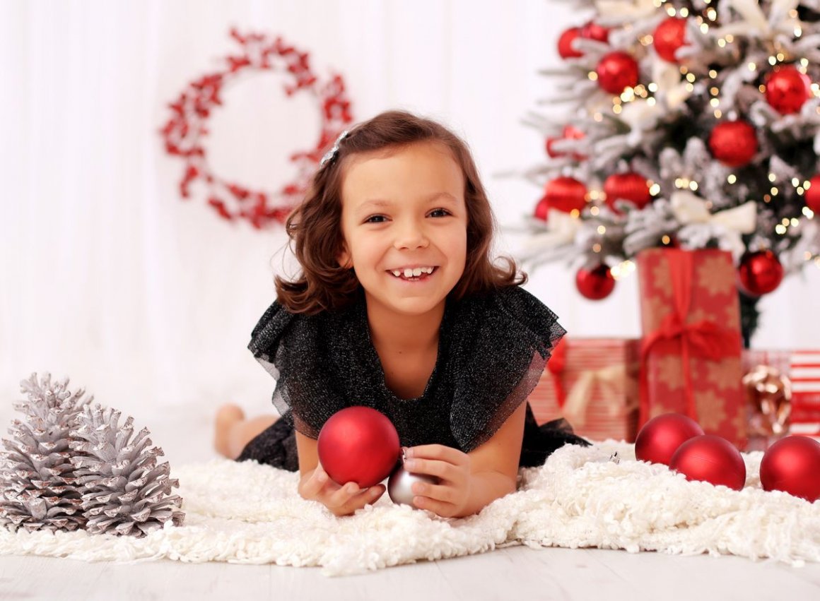 Vánoční fotka veselé hočičky v ateliéru v červeno bílém ladění