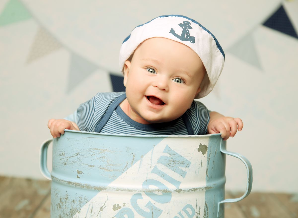 Roční miminko oblečené jako námořník se směje a vykukuje na ateliérové fotografii z velkého zavařovacího hrnce. | © Fotoprome.cz