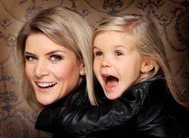 Detailní fotografie mámy a dcery v kožených bundách se zlatými tapetami při focení v luxusním prostoru ateliéru. 
